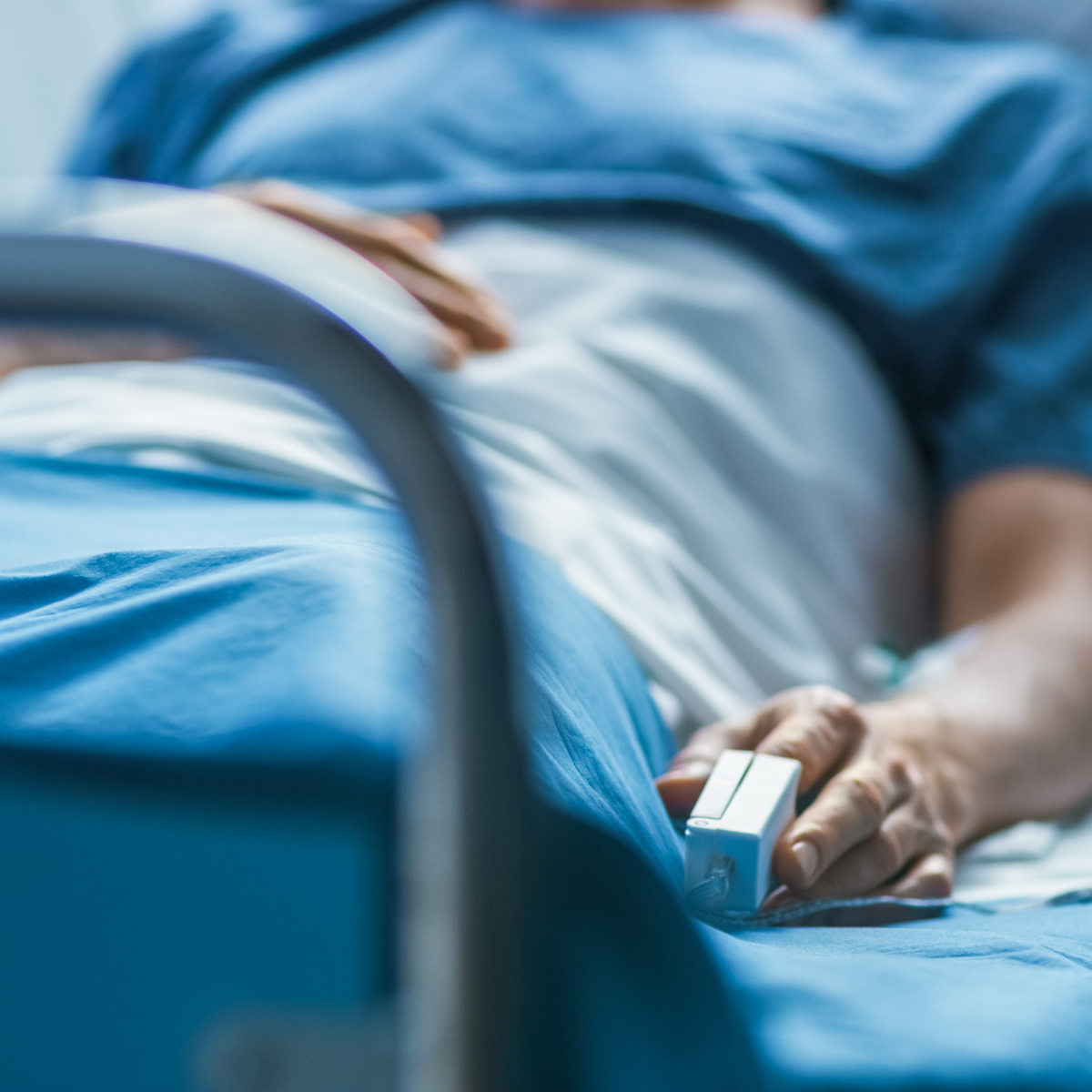 A person lying in a hospital bed to illustrate handling medical bills after a car accident